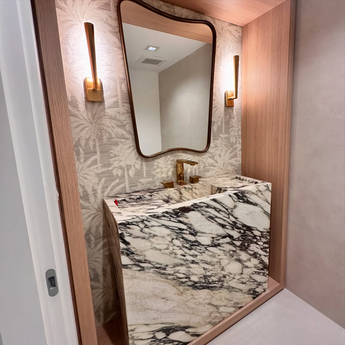 Elegant powder room with tropical wallpaper, marble and gold fixtures